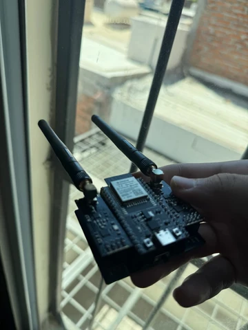 Bloqueador de som Bluetooth sendo segurado na mão perto de uma janela